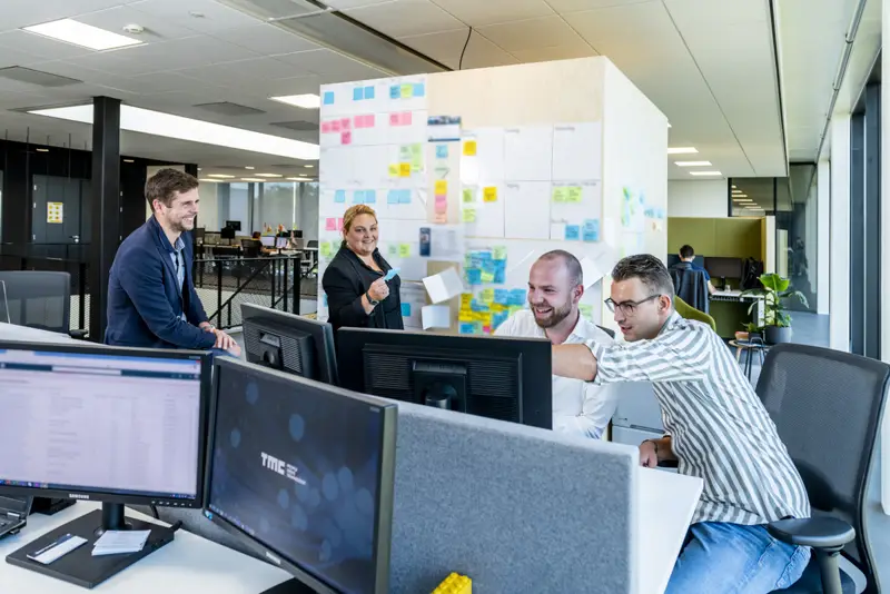 Collega's van TMC aan het werk bij een planbord vol post-its